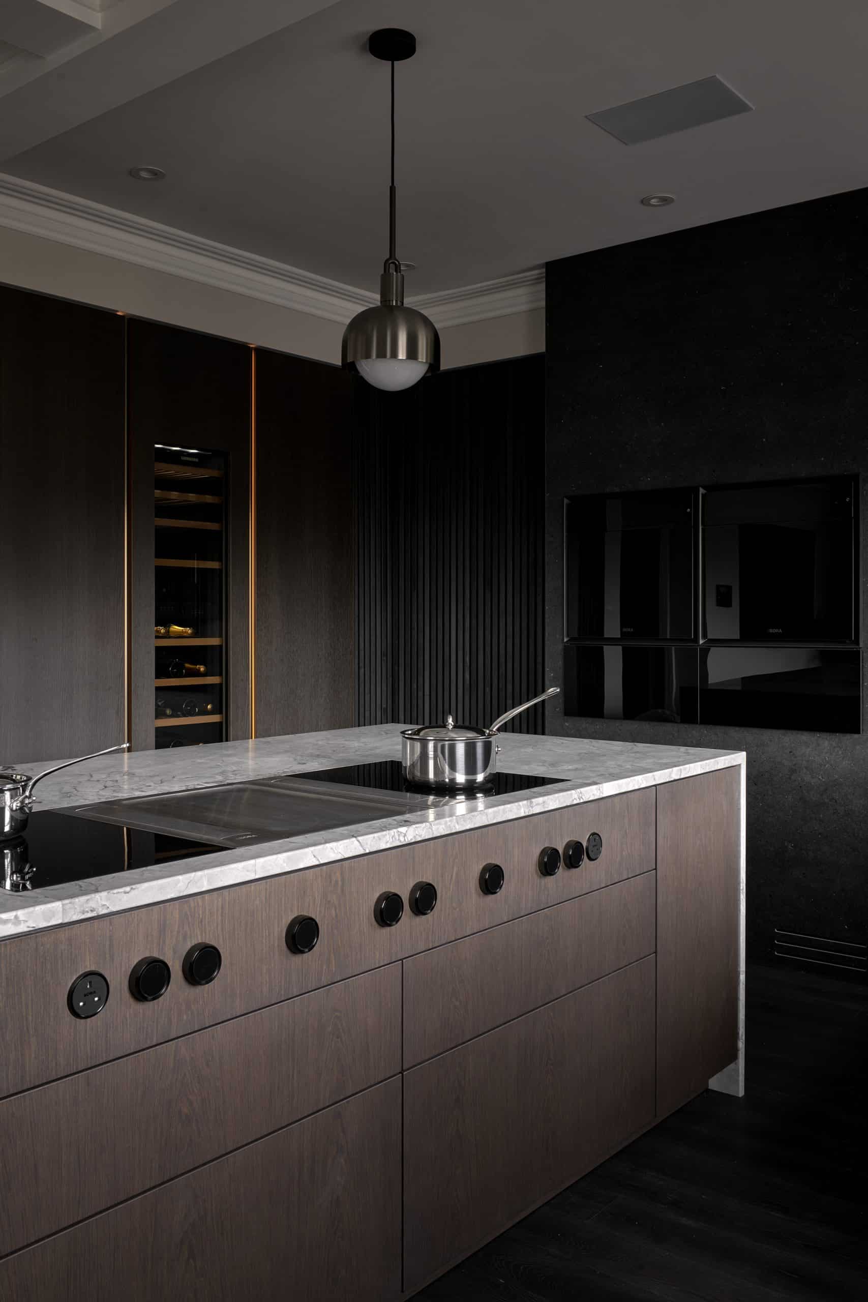 Contemporary modern kitchen design with black slatted wood wall, double Bora oven stack, Liebehr wine fridge and kitchen island with Bora hob and downdraft extractor.